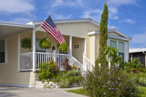 Yellow double-wide mobile home with American flag